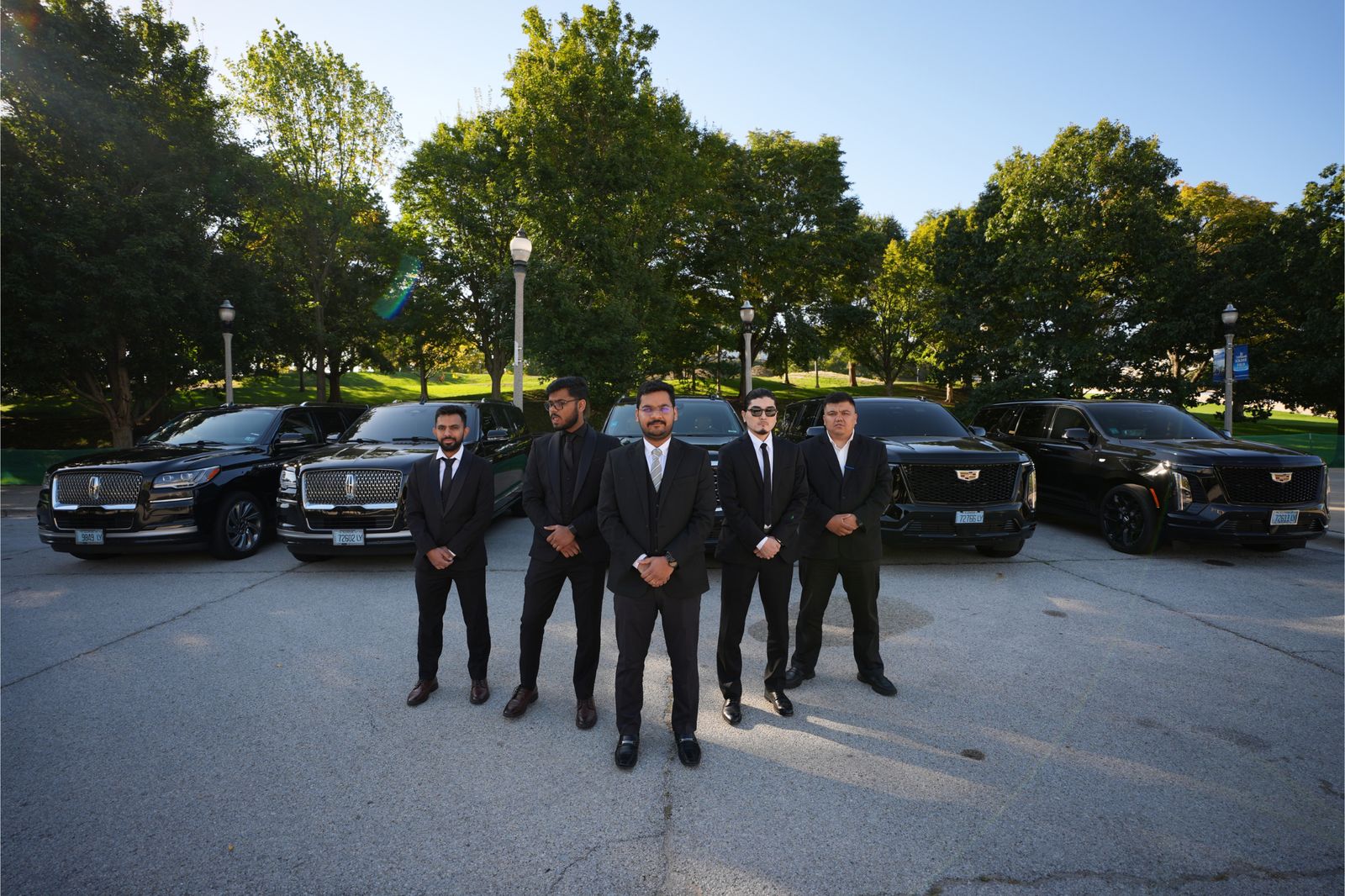 Vellaro chauffeurs in suits standing with the black SUV fleet